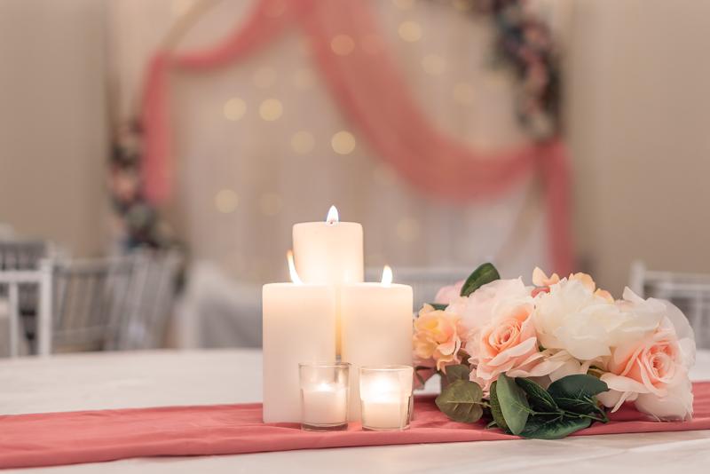 Candles and pink florals on a reception table