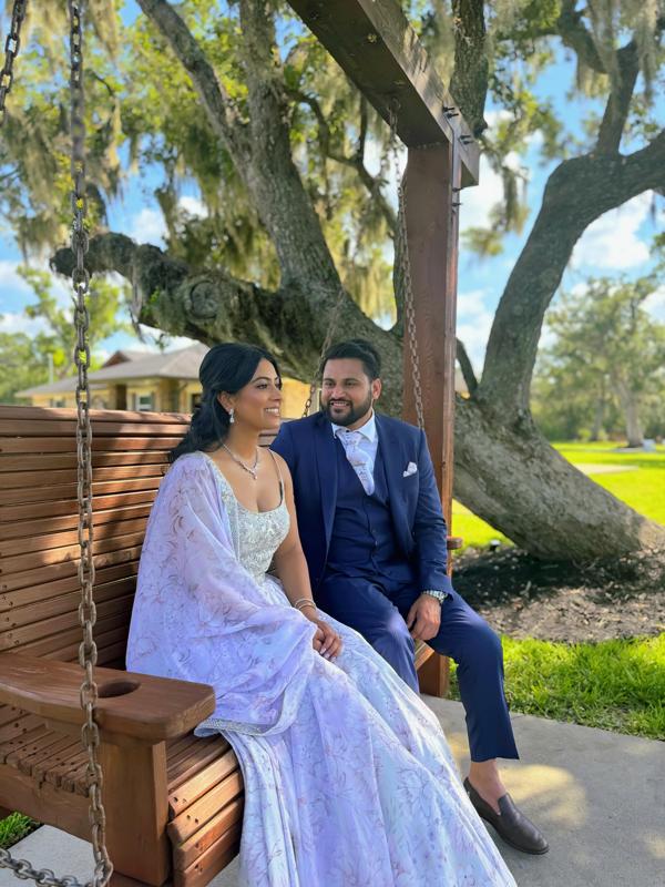 Couple on the wooden swing under the grand oak