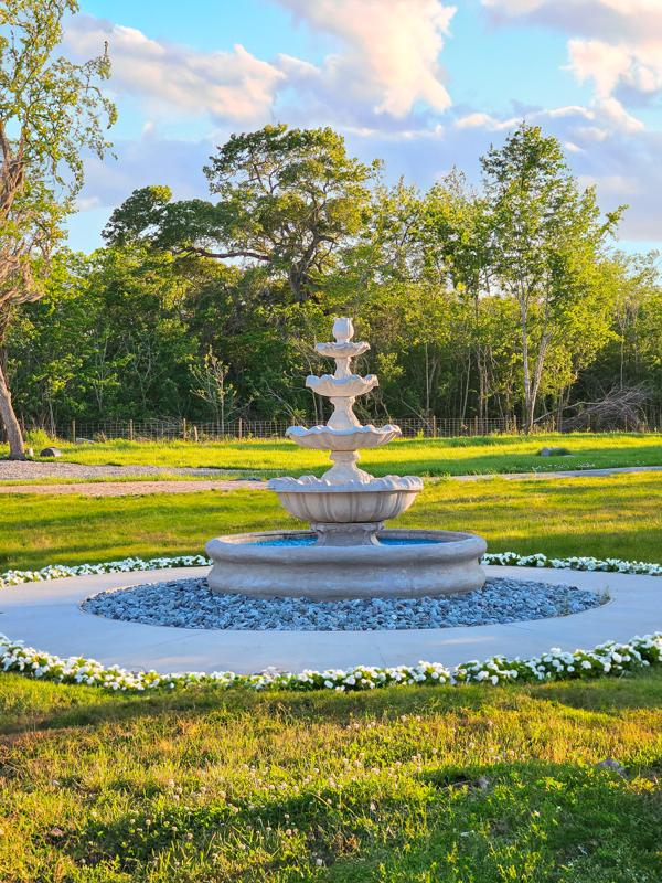 Entrance fountain surrounded by lawn and trees
