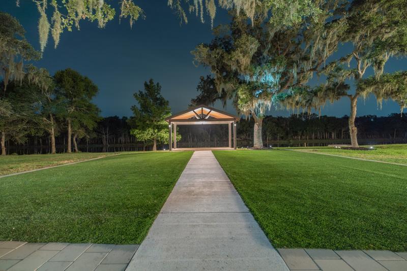 Lit walkway leading to the pavilion at night